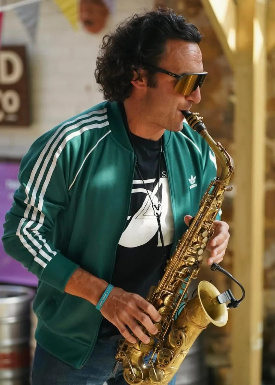 Tom playing saxophone alongside a DJ