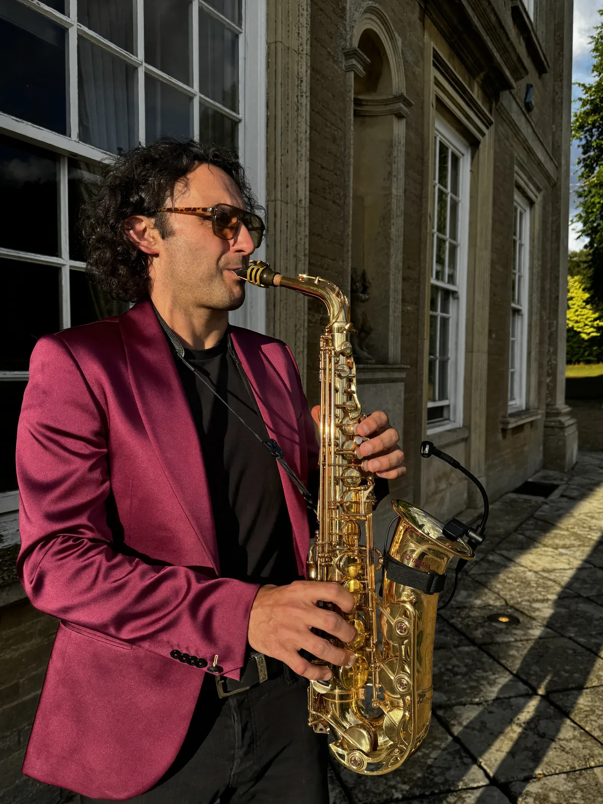 Tom playing saxophone outside a country house venue